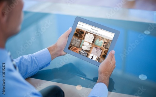 Composite image of businessman using his tablet 