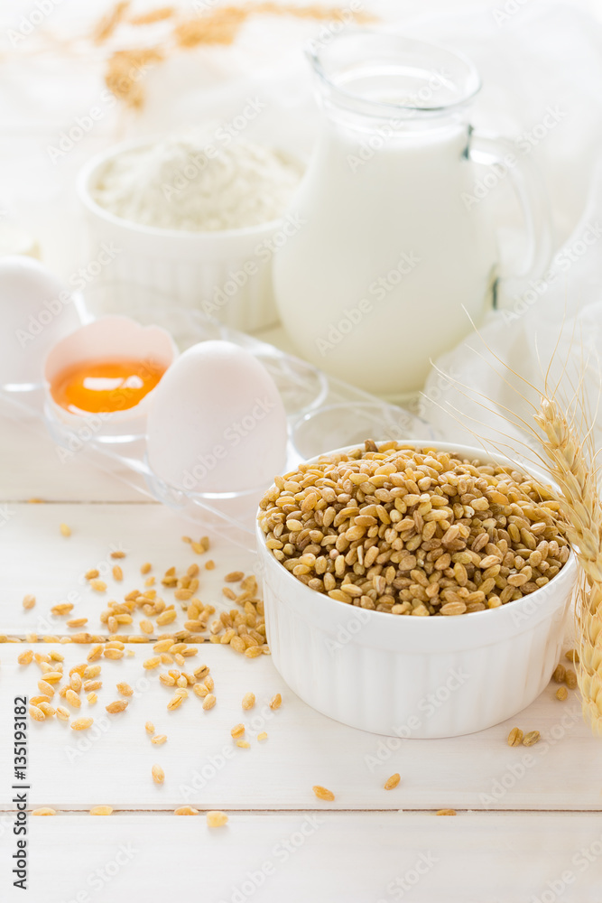 Ingredients for baking: flour, milk, wheat grain, butter and eggs on white wooden background. Selective focus
Ingredients for baking: flour, milk, wheat grain, butter and eggs on white wooden background. Selective focus