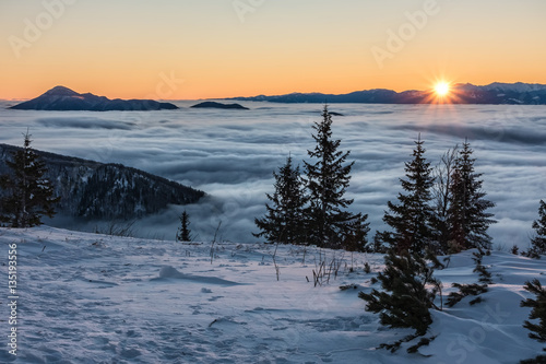 First sunrays on mountains above low clouds © Jaroslav Machacek
