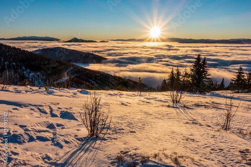Mountain sunrise above low clouds