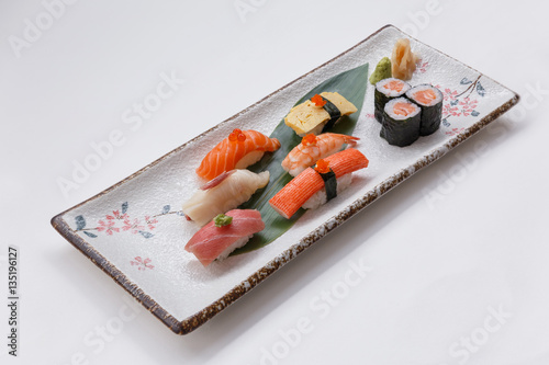 Sushi Set Include Maguro, Hamachi, Salmon, Kani, Shrimp, Tamagoyaki and Salmon Maki Roll Served with Wasabi and Prickled Ginger on Japanese Painted Stone Plate.