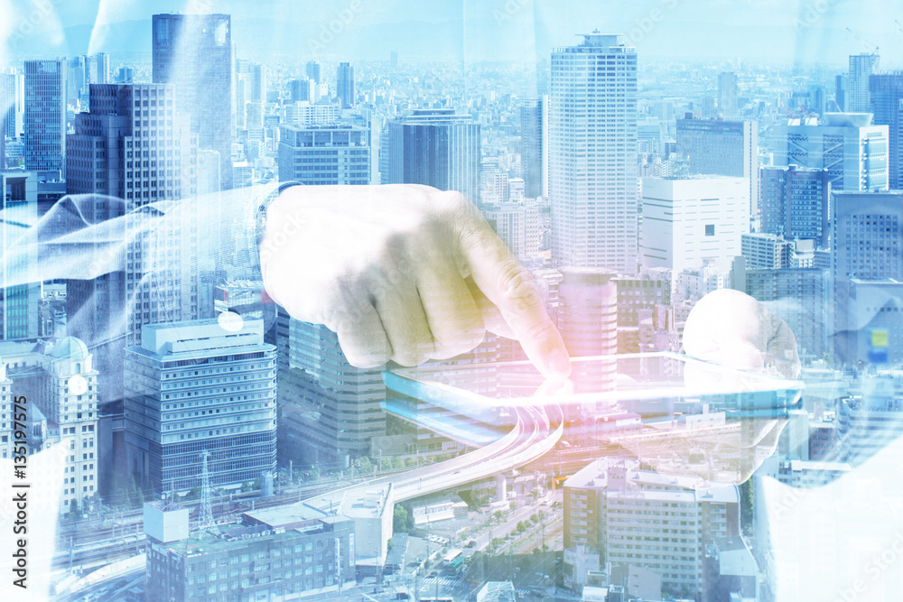 Double exposure of businessman hand touching digital tablet over