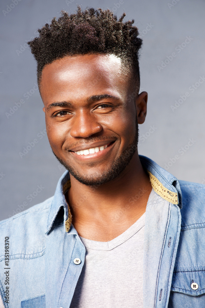 Fototapeta premium handsome smiling black man standing by gray background