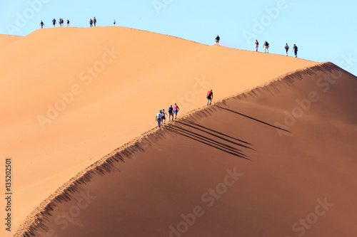 People Climbing a dune in Sossusvlei Namibia