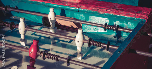 Ancient old wood classic aged Foosball table or table soccer with vintage effect photo style. Mini football close up concept.
