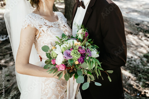bride and groom holding a bouquet. wedding flowers