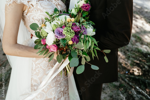 bride and groom holding a bouquet. wedding flowers