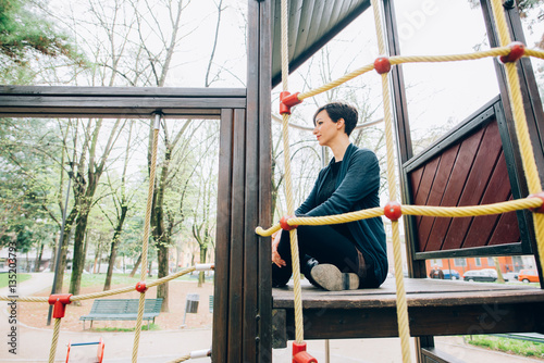 young handsome caucasian short brown hair woman having fun a playground - childhood, freshness, carefree concept