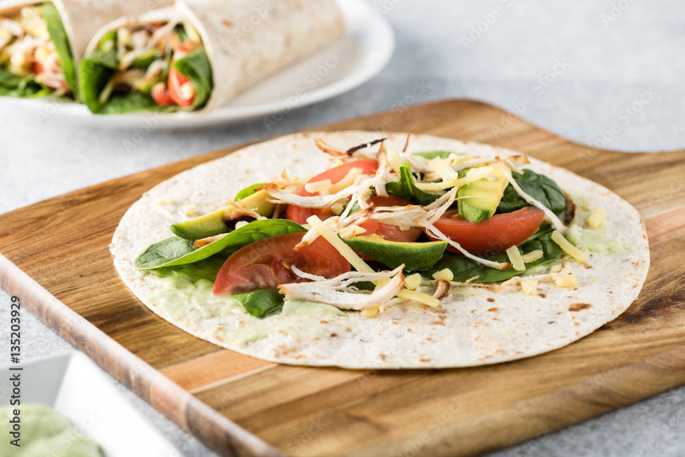 shredded barbecued chicken wraps with carrot, cheese, avocado an