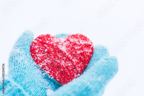 Blue knitted gloves with woolen heart. St. Valentine s Day greet
