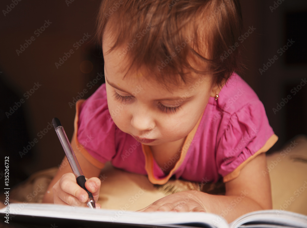 Little beautiful girl writing in her book Little beautiful girl writing in her book