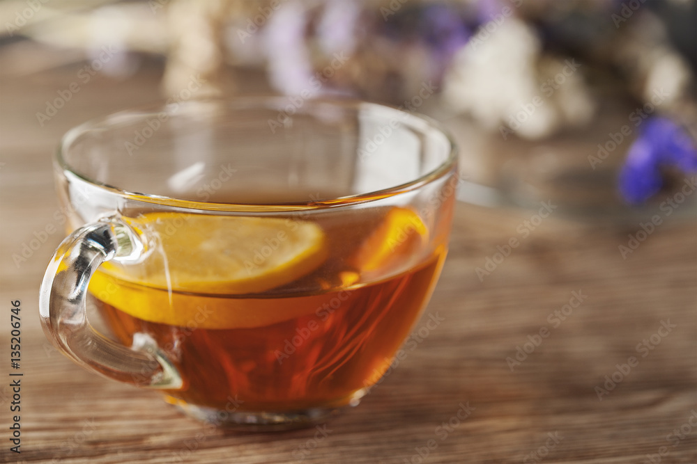 tea with lemon on a wooden table with wildflowers tea with lemon on a wooden table with wildflowers