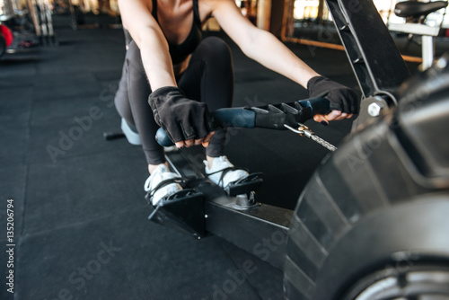 Woman athlete working out using fitness equipment in gym