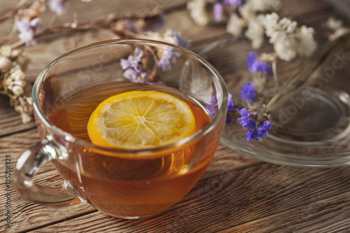 tea with lemon on a wooden table with wildflowers