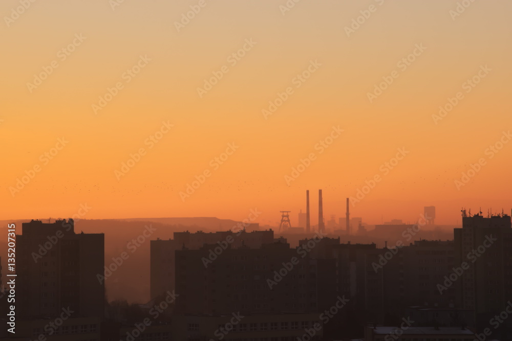 Naklejka premium Sunrise over the settlement with visible on the horizon coal mine