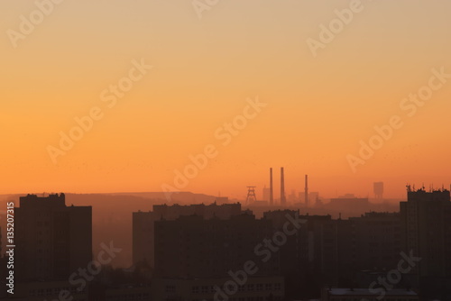 Sunrise over the settlement with visible on the horizon coal mine