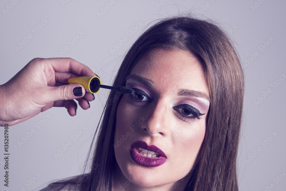 Close up of makeup artist putting mascara on a woman's eyelashes. Close-up of a woman's face. Woman putting mascara on.