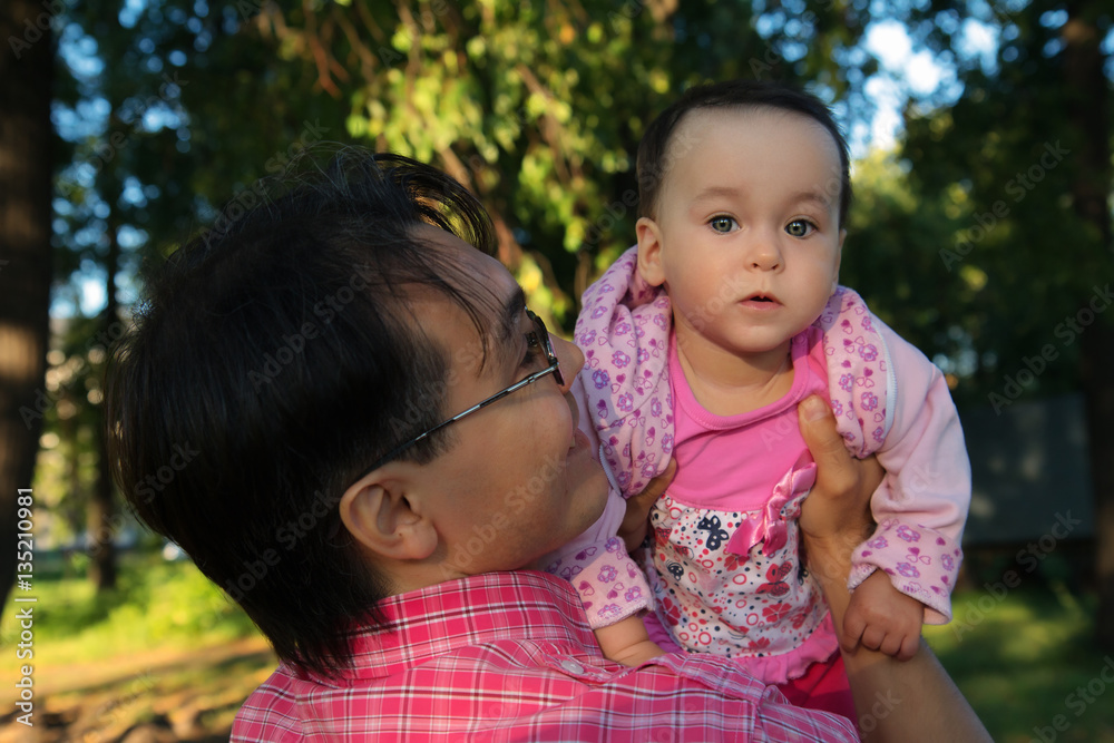 Youg man holding his daughter, close up portrait in the Park Youg man holding his daughter, close up portrait in the Park