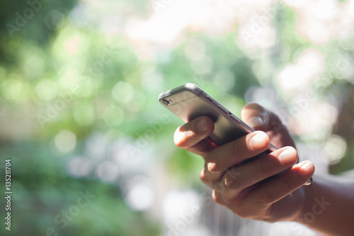 Closeup on a man's hands as he is using a smart phone.