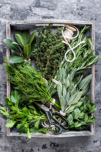 fresh herbs in wooden box on stone background