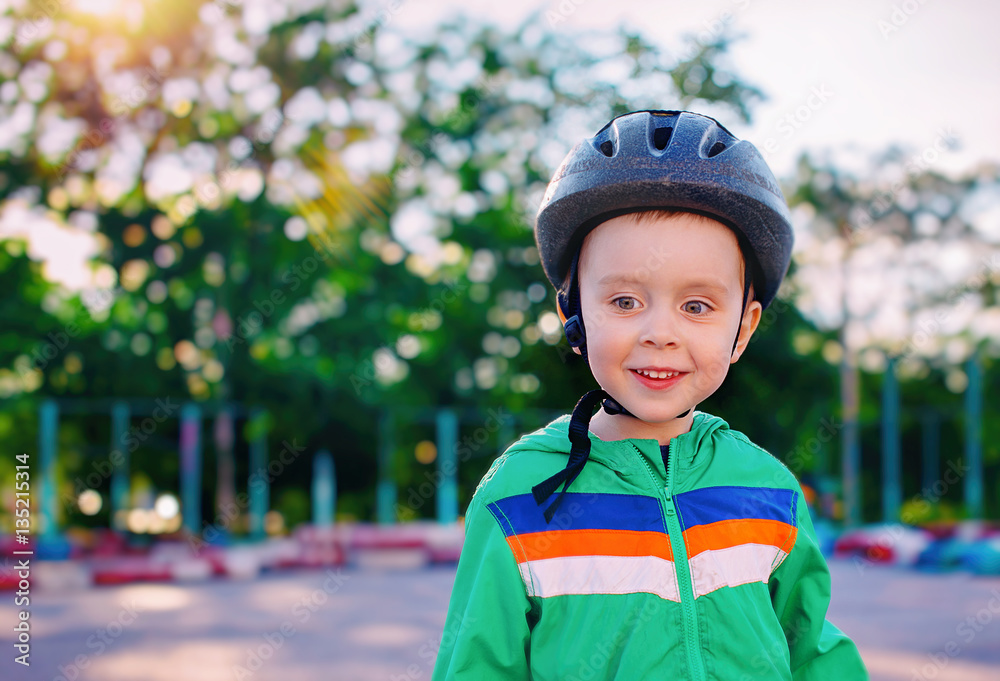 smiling boy in a bicycle helmet. kid on a sports ground outdoors smiling boy in a bicycle helmet. kid on a sports ground outdoors