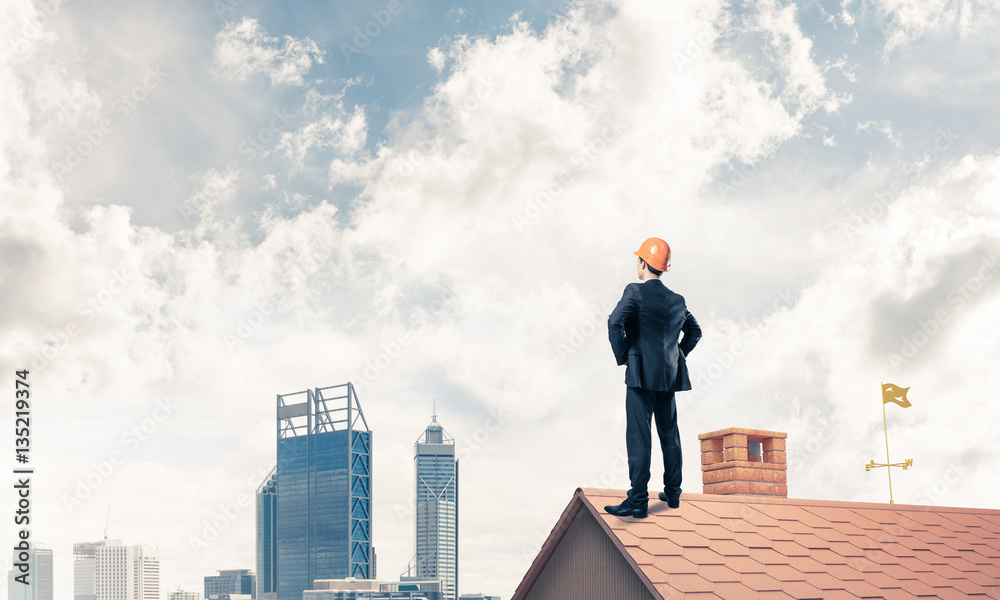 Engineer man standing on roof and looking away. Mixed media Engineer man standing on roof and looking away. Mixed media