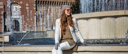 happy tourist woman in Milan, Italy sitting near fountain