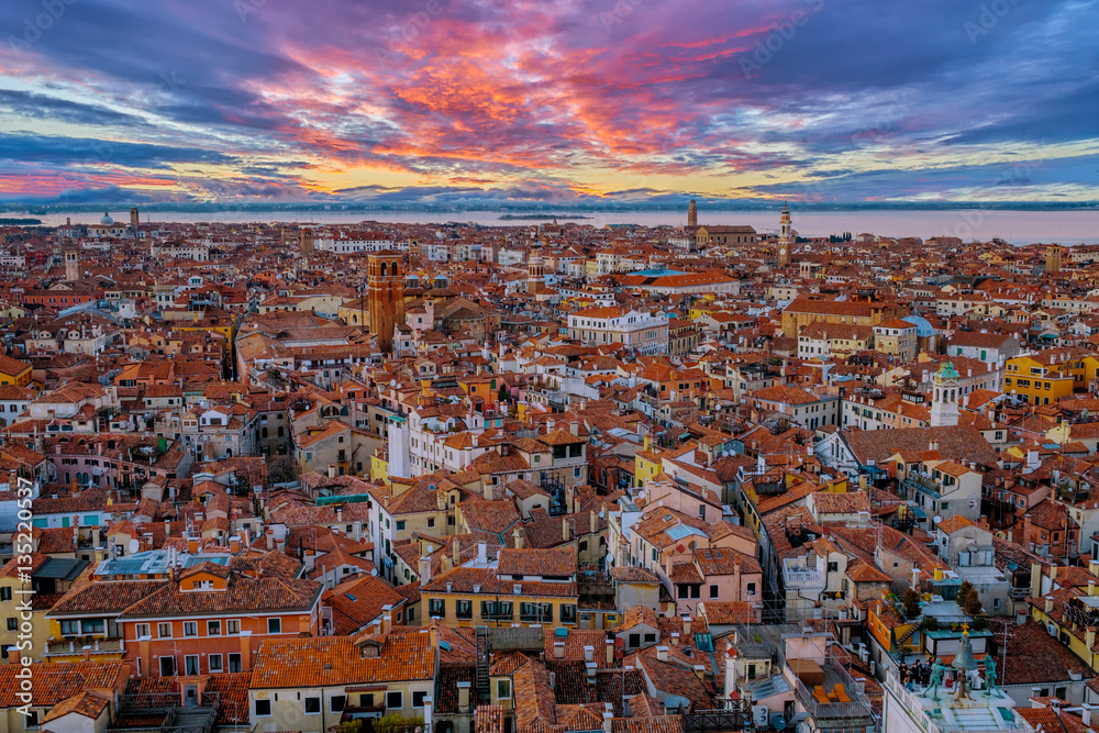 Aerial view of Venice, Italy, at sunset with rooftops of buildings and vivid colors in winter afternoon.