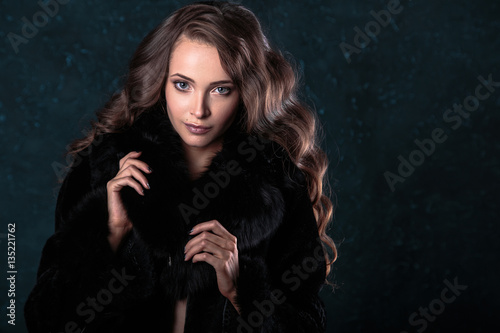 Young brunette woman with perfect natural makeup and hair style wearing furs. fashion beauty portrait 