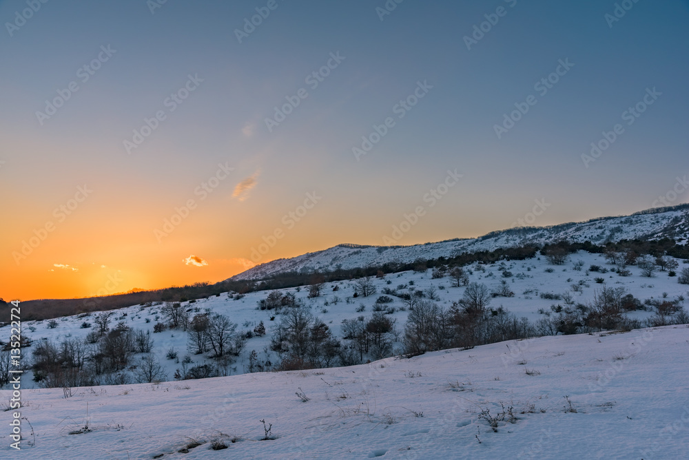 Beautiful winter mountain sunset with a breathtaking orange sky. Russia, Stary Krym.