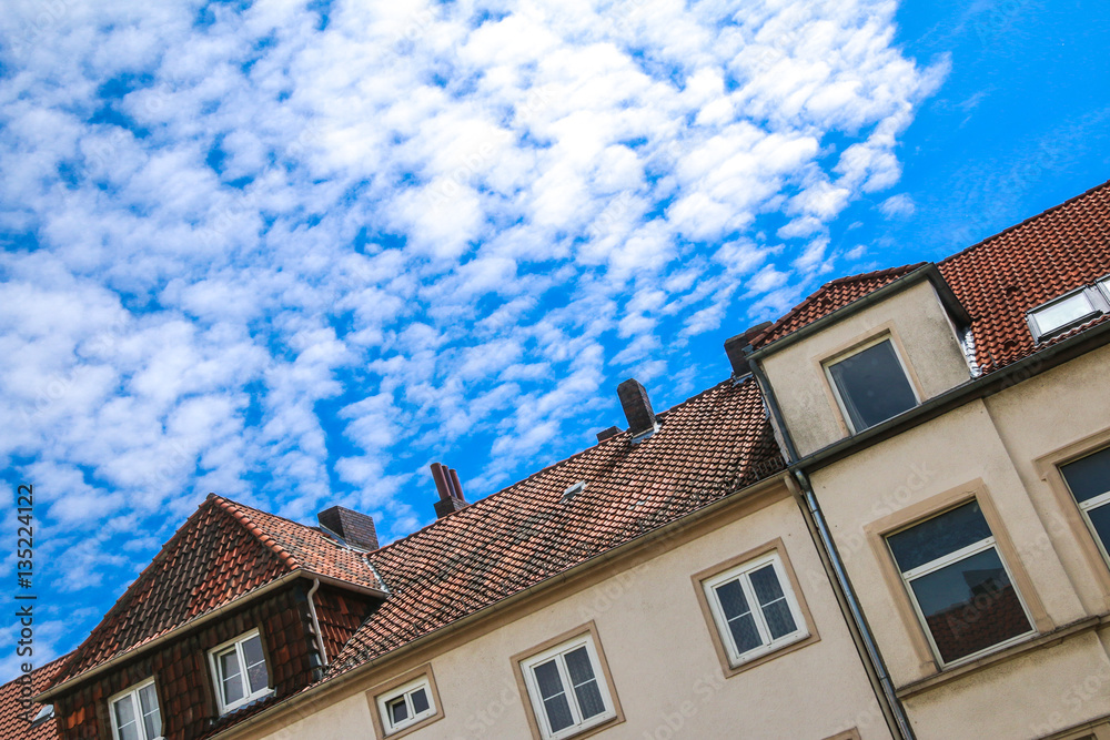 Hausdach mit wolkigem Himmel