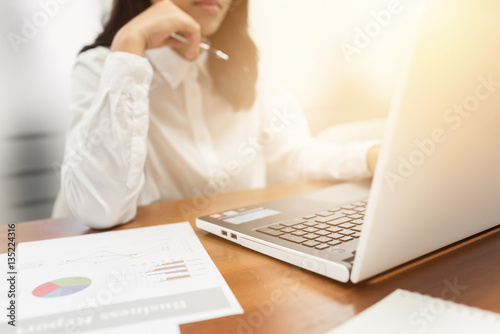 Young businesswoman working with document and laptop computer in office.