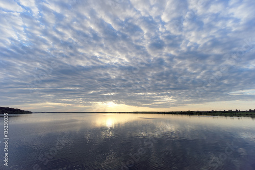 View of the golden sunset on the river with clouds and the Sun reflected in it  Volga  Russia