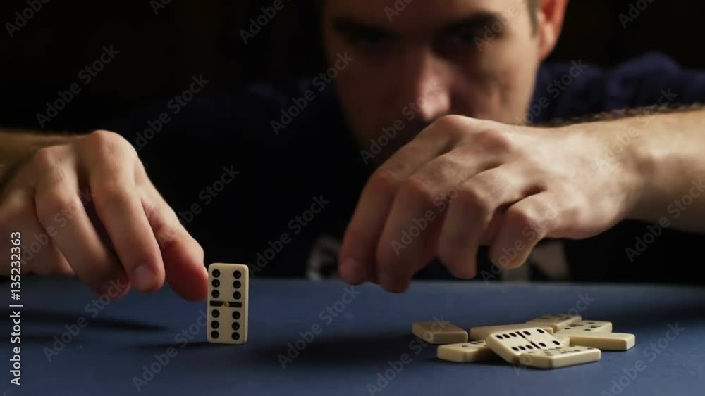 Man set up the domino with hand. Domino effect