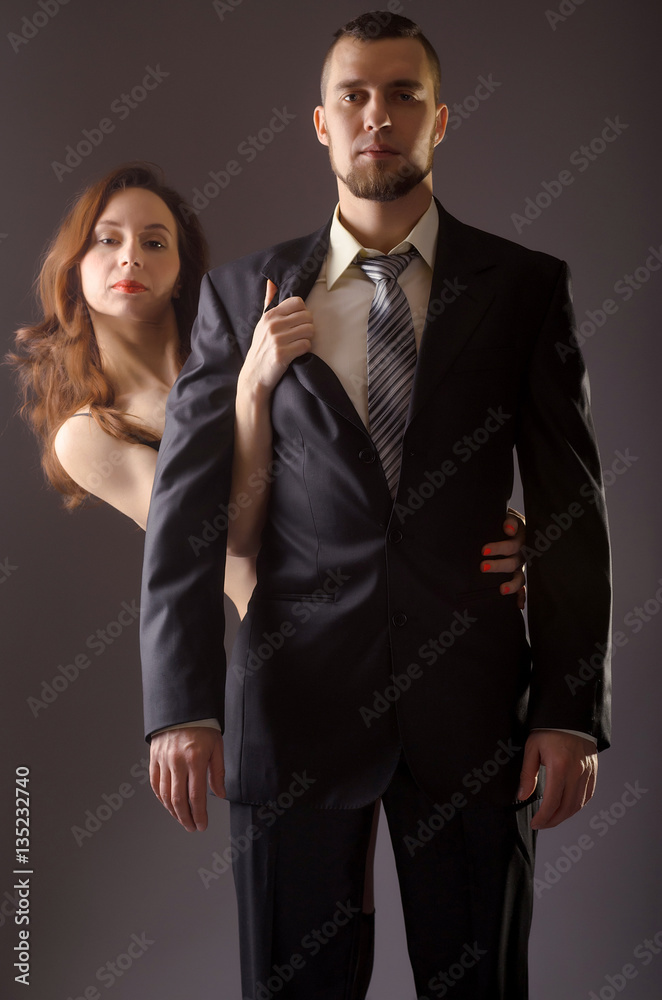 Stylish man in a suit and tie on gray background. Stylish man in a suit and tie on gray background.