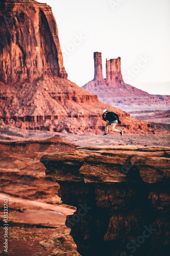 Man in mid air jumping on sandstone rocks