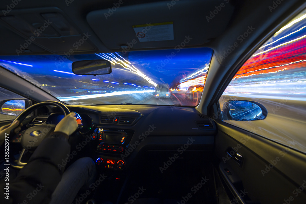 The car moves at great speed.Blured road with lights with car on high speed. Concept rapid rhythm of a modern city.