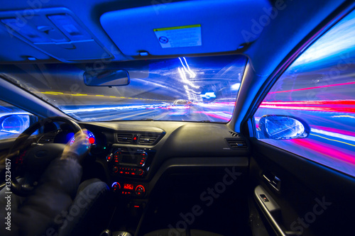 The car moves at great speed.Blured road with lights with car on high speed. Concept rapid rhythm of a modern city.