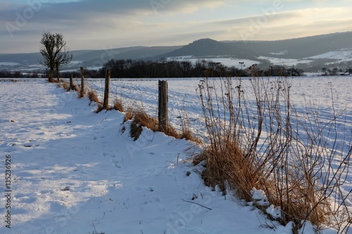 Winterlandschaft mit dem Rest eines alten Holzzaun im Morgenlicht