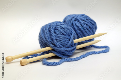 Blue knitting wools and knitting needles on white background