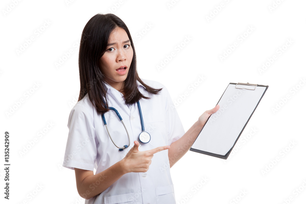 Asian young female doctor upset point to blank clipboard. Asian young female doctor upset point to blank clipboard.