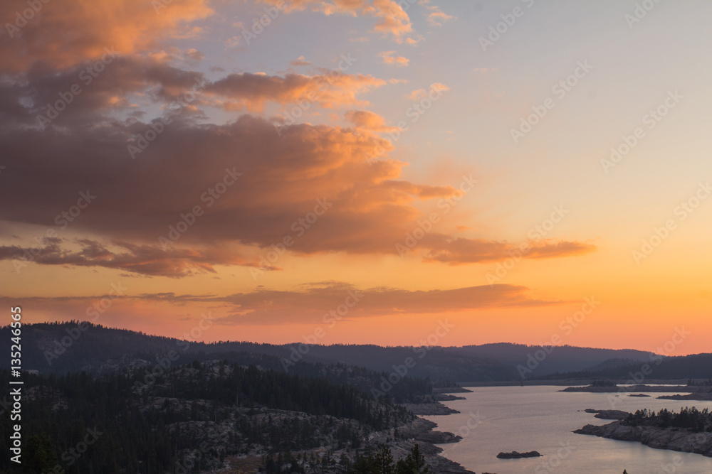 Sunset over a high sierra lake and granite mountains and forest