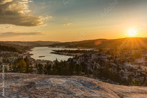 Sunset over a high sierra lake and granite mountains and forest