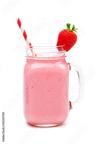 Pink strawberry smoothie in a mason jar glass with straw isolated on white
