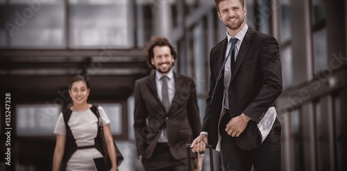 Smiling businesswoman with colleagues walking