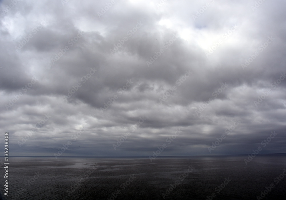 Gushing sea on a cloudy day. Horizontal view of dramatic overcast sky and sea. Fifty shades of blue. Gushing sea on a cloudy day. Horizontal view of dramatic overcast sky and sea. Fifty shades of blue.