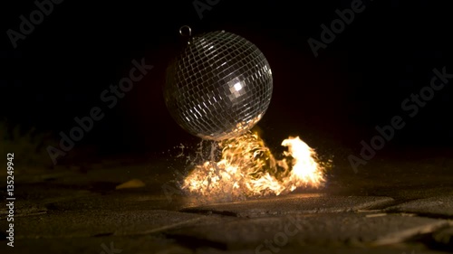 Disco ball falling and catching fire, slow motion