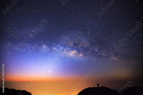 milky way galaxy and silhouette of a standing happy man on Doi L