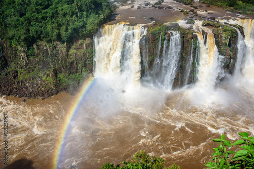 Rainbow and view of cascading water of Iguazu Falls with extensive tropical forest and raging river in Iguacu National Park  UNESCO World Heritage Site  Foz de Iguacu  Parana State  Brazil