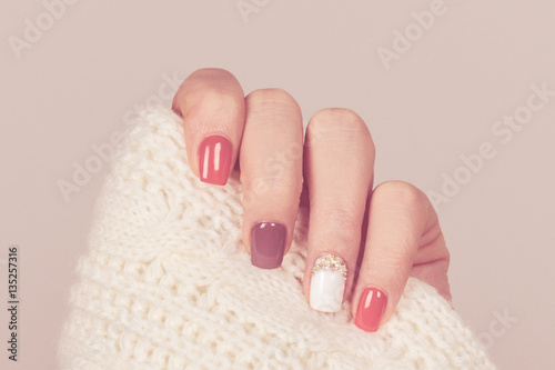 Beautiful colored pastel colors nail polish on hand, closeup. Nail art manicure concept